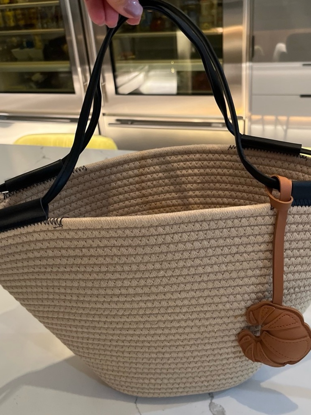 Woven Straw Tote Bag with Black Handles and Tan Charm